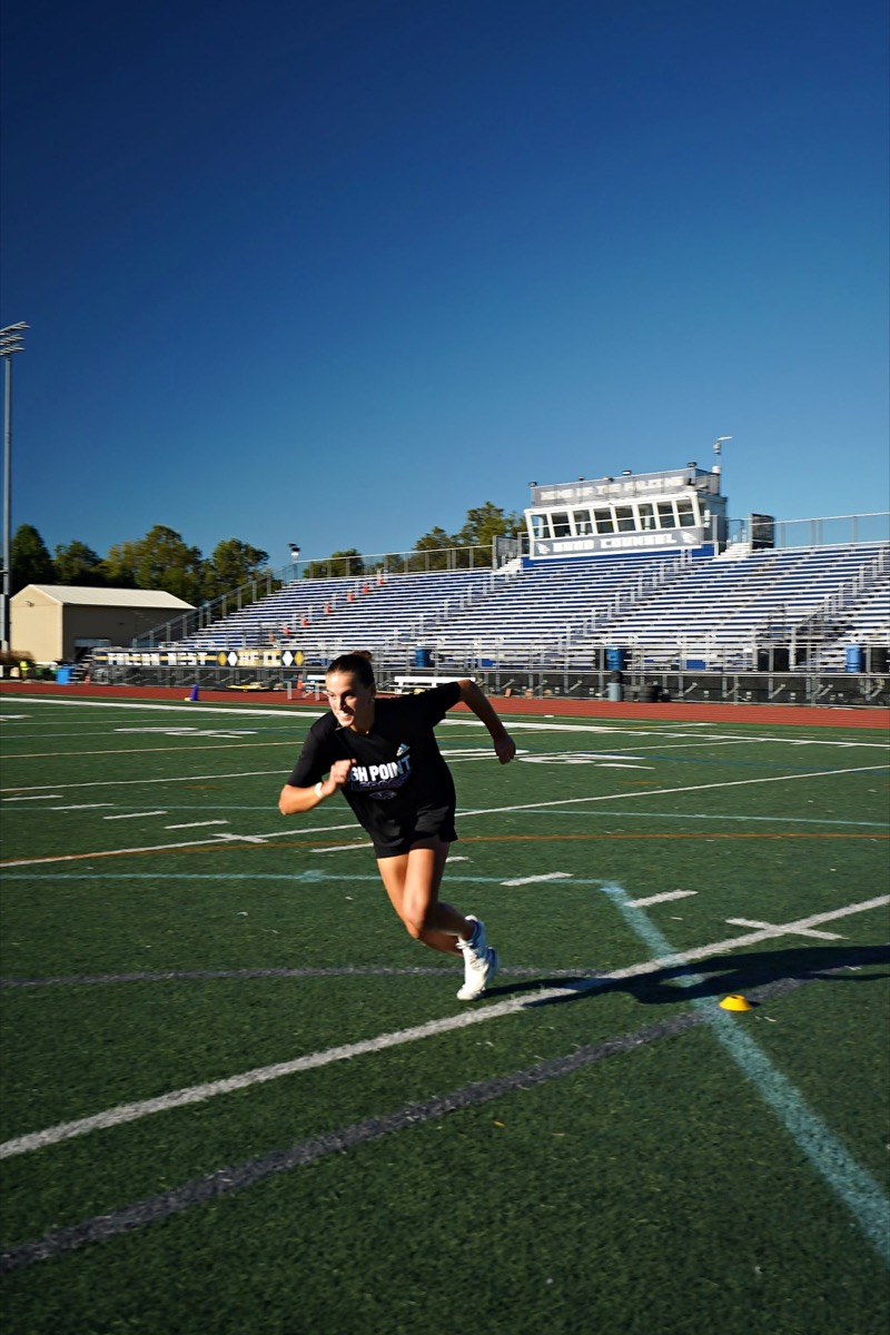 Ava Grandi running sprint drills on a track field