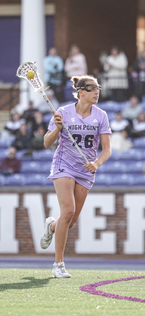 Ava Grandi playing lacrosse in a High Point University uniform